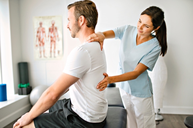 A chiropractor examines a patient to know where to adjust